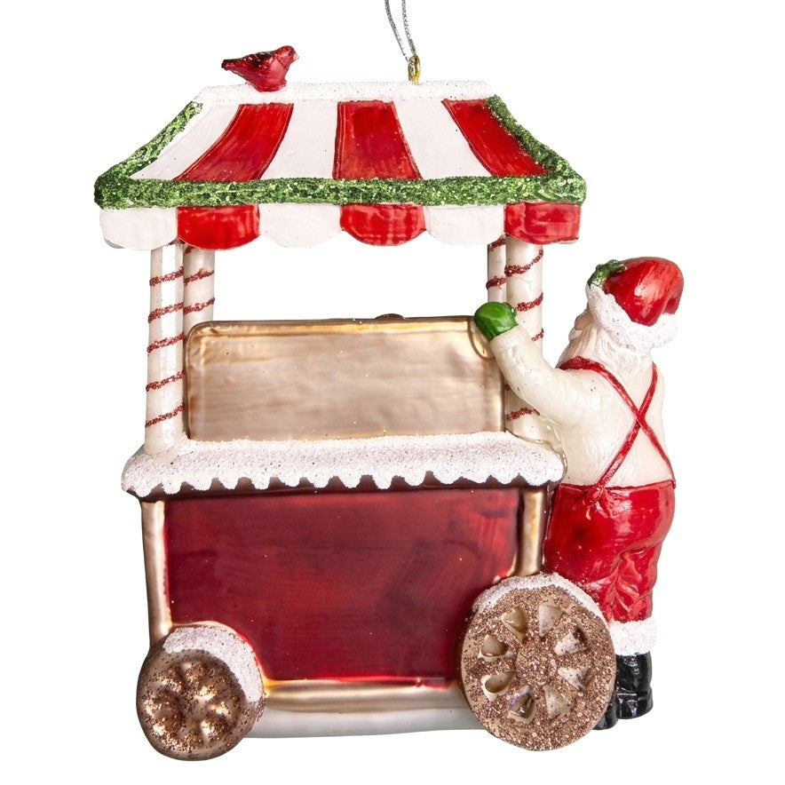 Retro dell’addobbo con Babbo Natale accanto al banchetto dei dolci, tendina a righe rosse e bianche e ruote glitterate
