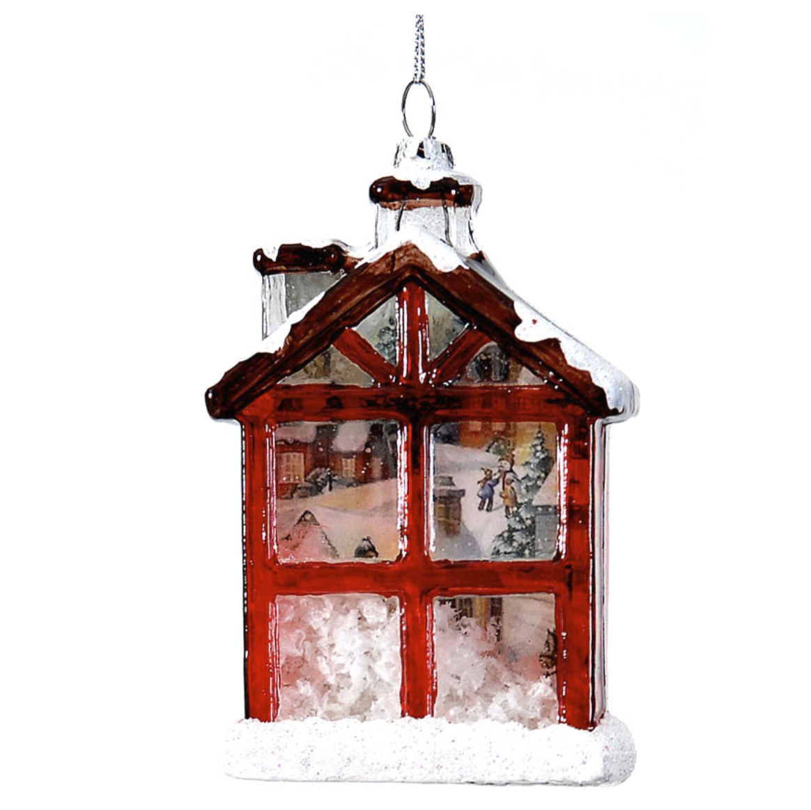 Addobbo di vetro a forma di casetta con facciata a vetri e cornice rossa, tetto marrone innevato e comignolo; nei vetri si vede una scena invernale dipinta, con neve sul fondo