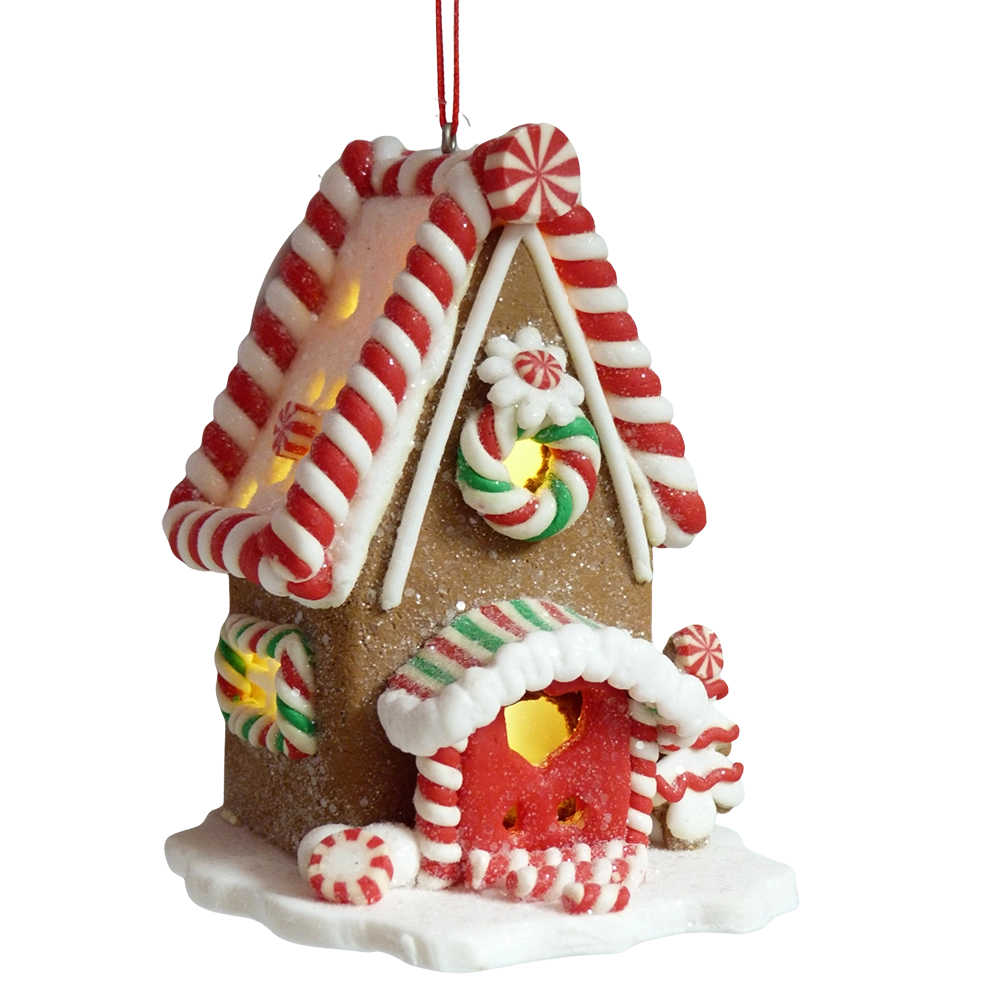 Casetta di pan di zenzero marrone con tetto a bastoncini rossi e bianchi, porta rossa con cuore dorato e alberello di glassa illuminata