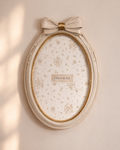 cornice ovale stile shabby beige con fiocco centrale