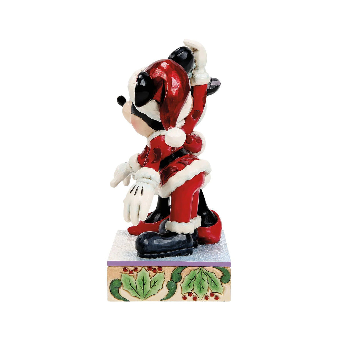 Vista laterale: Topolino in profilo con cappello rosso da Babbo Natale e orecchie a scacchi blu, con Minnie dietro di lui che alza il braccio con il vischio
