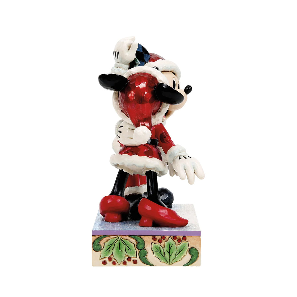 Vista laterale: Minnie di spalle con cappello rosso, pompon bianco e scarpe rosse col tacco, abbracciata a Topolino, su base con agrifoglio e bacche