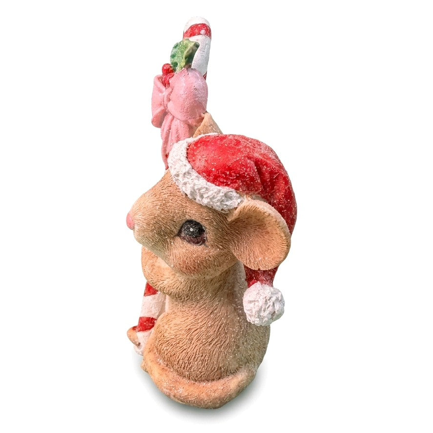 Dettaglio del topino natalizio in resina con cappello rosso glitterato, fiocco rosa e bastoncino di zucchero sullo sfondo